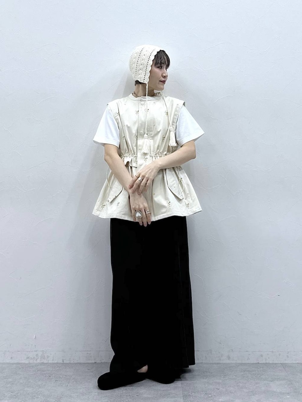 ブラック系のモカシン/デッキシューズ、ブラック系のスカート、ホワイト系のTシャツ/カットソーを着用したレディースの春コーディネートの2枚目の写真