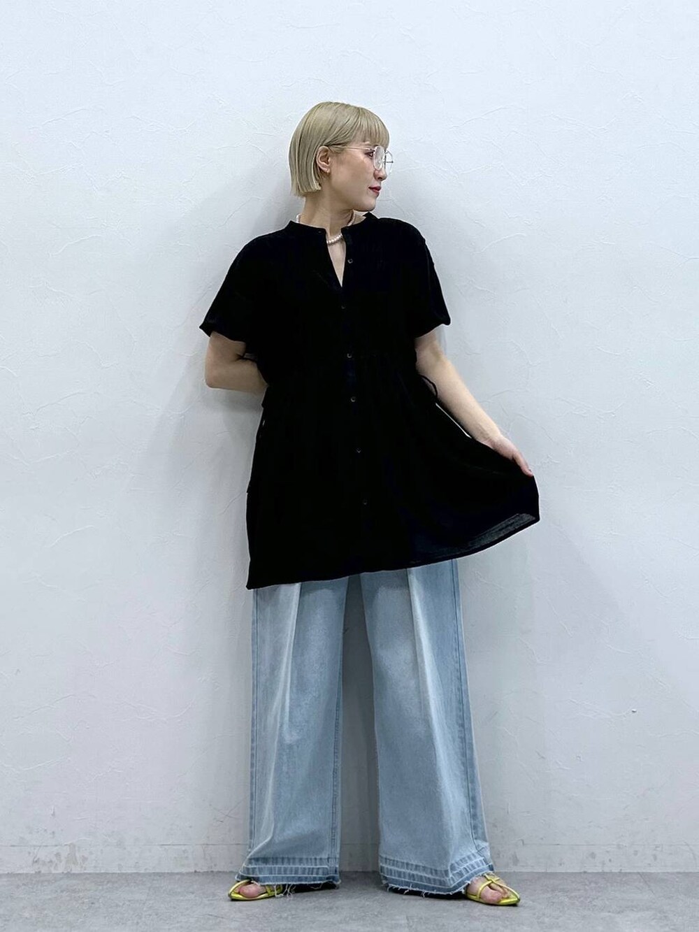 ブルー系のデニムパンツ、ブラック系のシャツ/ブラウス、ブラック系のメガネを着用したレディースの夏コーディネートの3枚目の写真