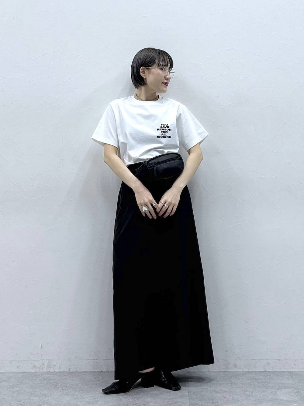 ブラック系のボディバッグ/ウエストポーチ、ブラック系のスカート、ホワイト系のTシャツ/カットソーを着用したレディースの春コーディネートの5枚目の写真
