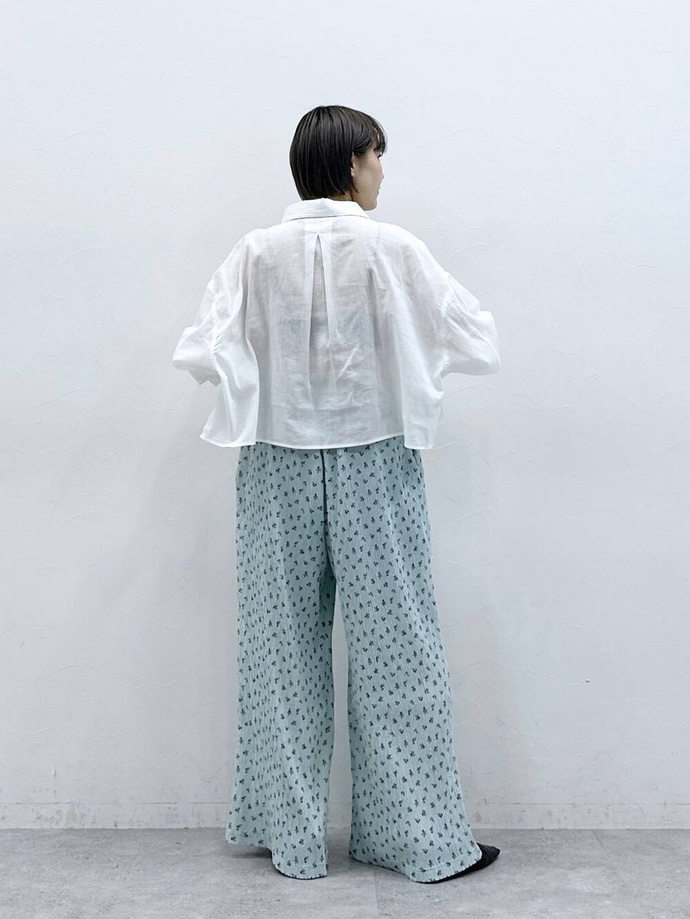 ホワイト系のシャツ/ブラウス、ブルー系のスラックスを着用したレディースの春コーディネートの5枚目の写真