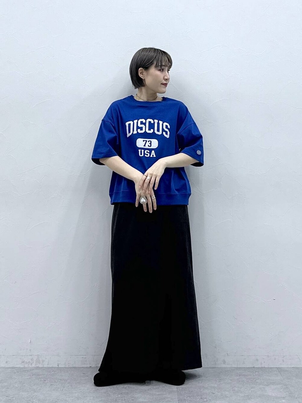 ブルー系のTシャツ/カットソー、ブラック系のモカシン/デッキシューズ、ブラック系のスカートを着用したレディースの春コーディネートの2枚目の写真