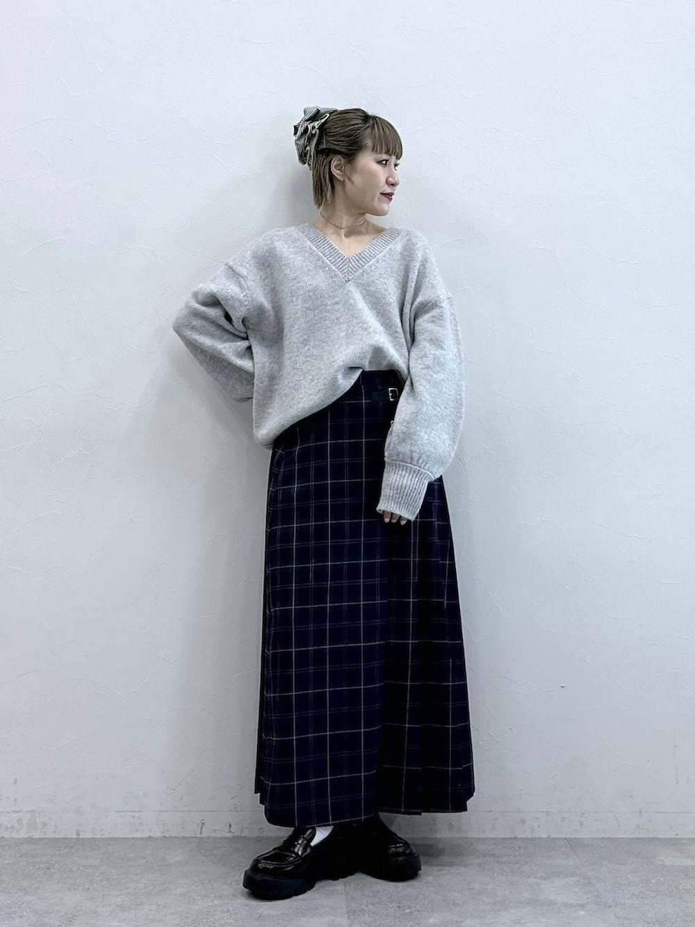 ブラック系のローファー、グリーン系のスカート、グレー系のニット/セーターを着用したレディースの冬コーディネートの3枚目の写真