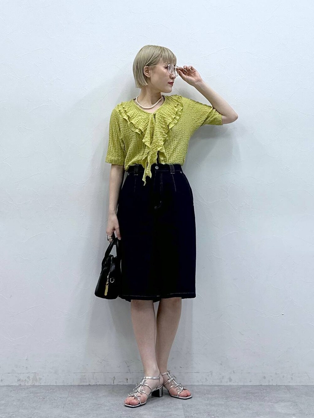 イエロー系のシャツ/ブラウス、ブルー系のデニムパンツ、ブラック系のメガネを着用したレディースの夏コーディネートの2枚目の写真