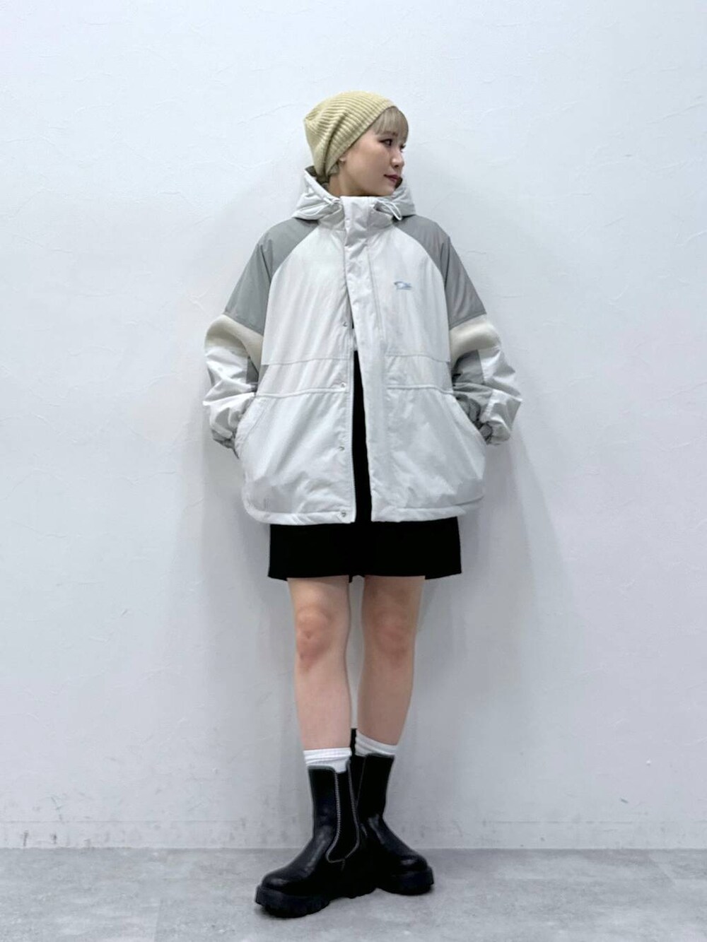 ブラック系のチノパンツ、ブラック系のブーツ、グレー系のダウンジャケット/コートを着用したレディースの秋コーディネートの2枚目の写真