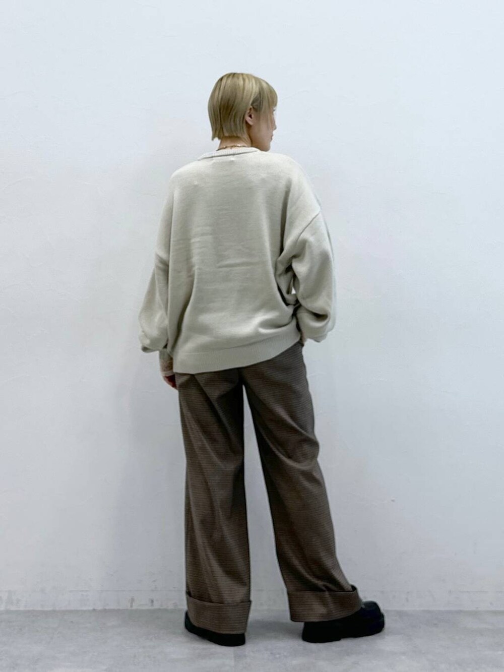 ホワイト系のニット/セーター、ブラック系のローファー、ブラウン系のスラックスを着用したレディースの秋コーディネートの5枚目の写真