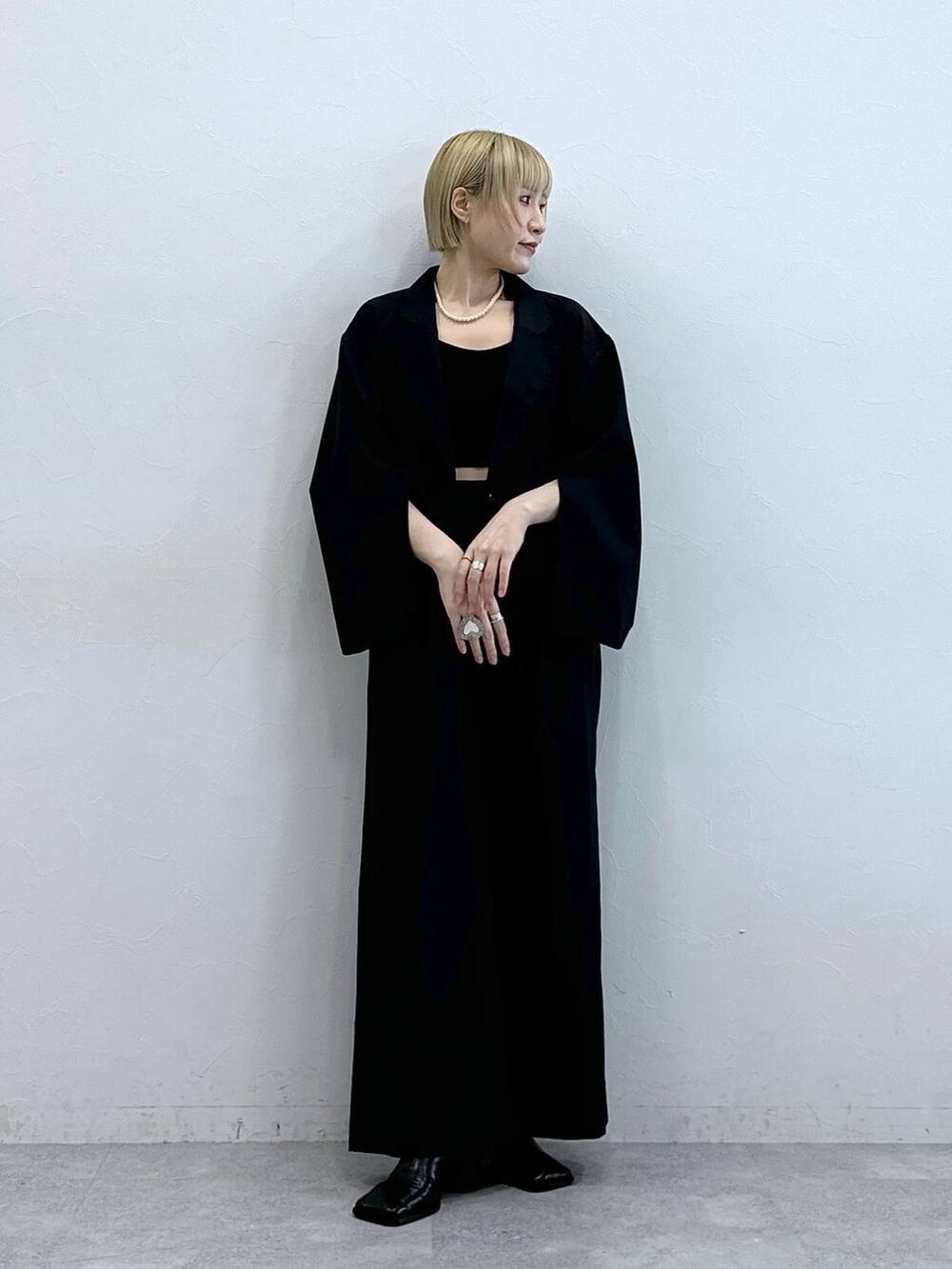 ブラック系のテーラードジャケット、ブラック系のブラジャーを着用したレディースの秋コーディネートの4枚目の写真