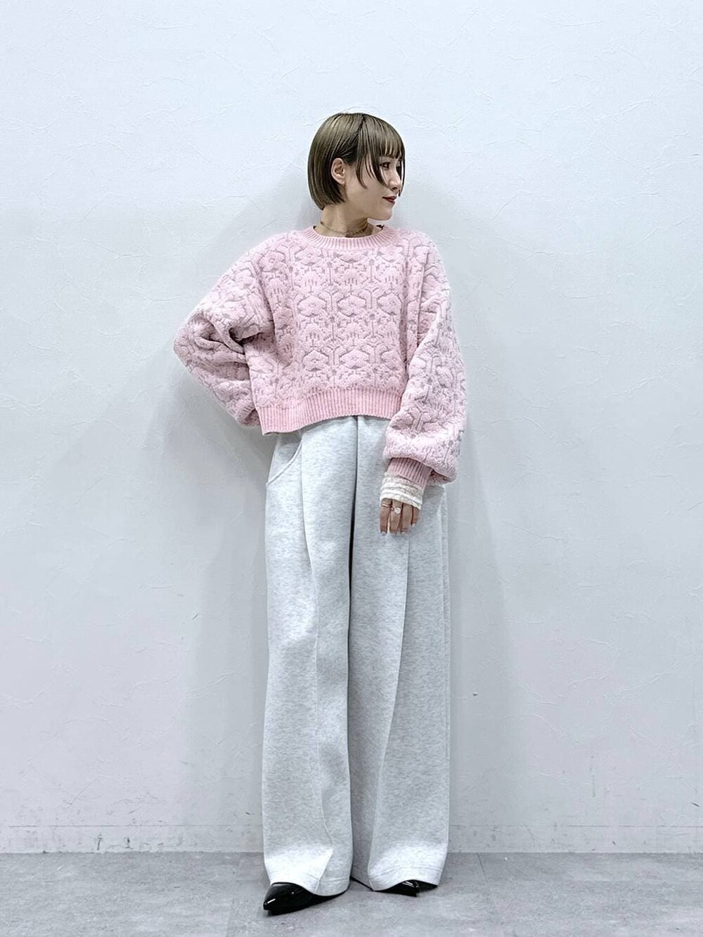 ホワイト系のTシャツ/カットソー、ブラック系のパンプス、ピンク系のニット/セーターを着用したレディースの冬コーディネートの3枚目の写真