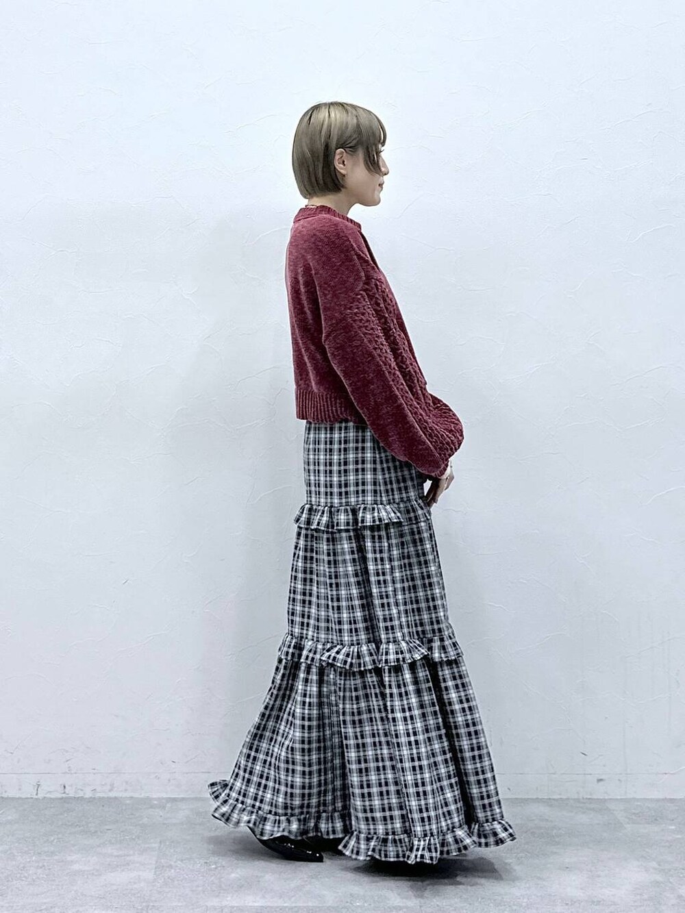 レッド系のニット/セーター、ブラック系のスカート、ブラック系のパンプスを着用したレディースの冬コーディネートの4枚目の写真