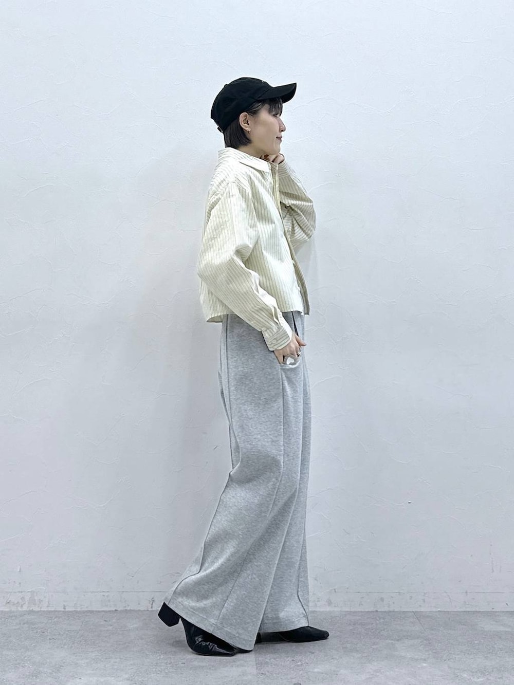 イエロー系のシャツ/ブラウス、グレー系のスウェットパンツ、ブラック系のキャップを着用したレディースの春コーディネートの4枚目の写真