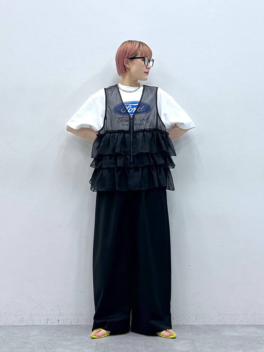 ブラック系のスラックス、ホワイト系のTシャツ/カットソー、ブラック系のベストを着用したレディースの春コーディネートの3枚目の写真