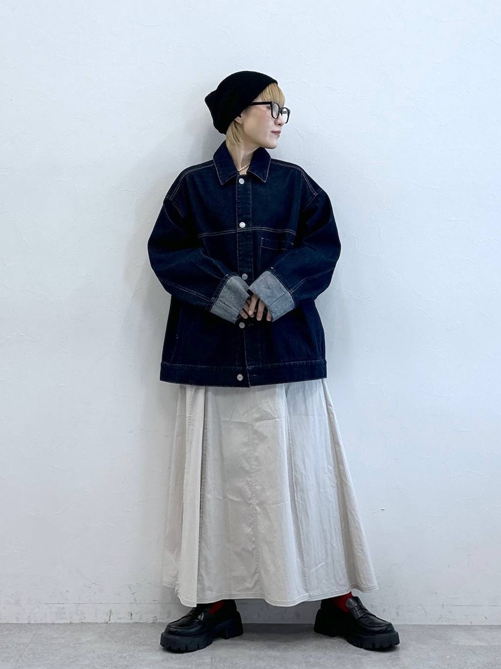 ブラック系のローファー、ブルー系のデニムジャケット、ホワイト系のスカートを着用したレディースの夏コーディネートの5枚目の写真