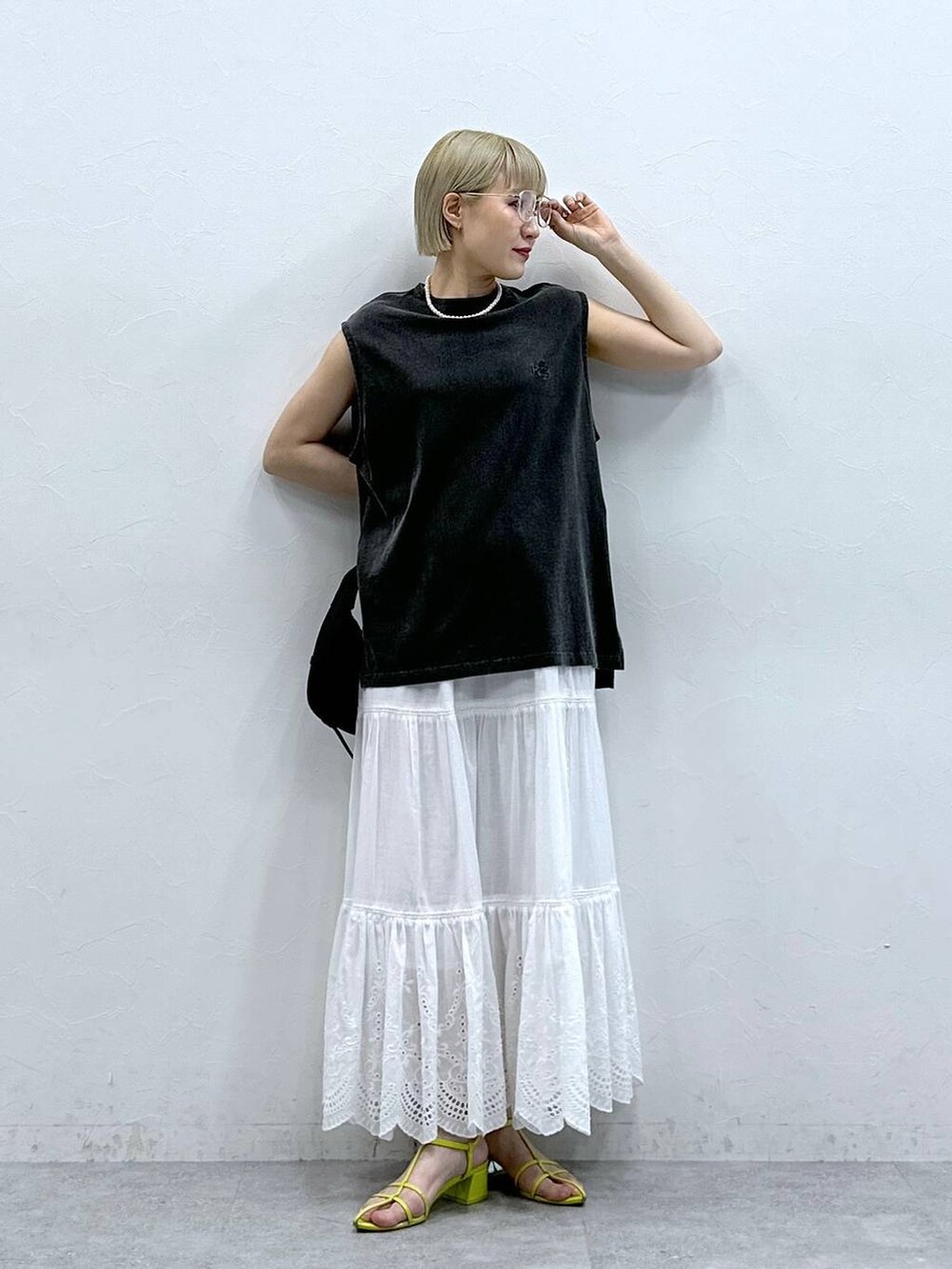 ブラック系のTシャツ/カットソー、ホワイト系のスカート、ブラック系のメガネを着用したレディースの夏コーディネートの2枚目の写真