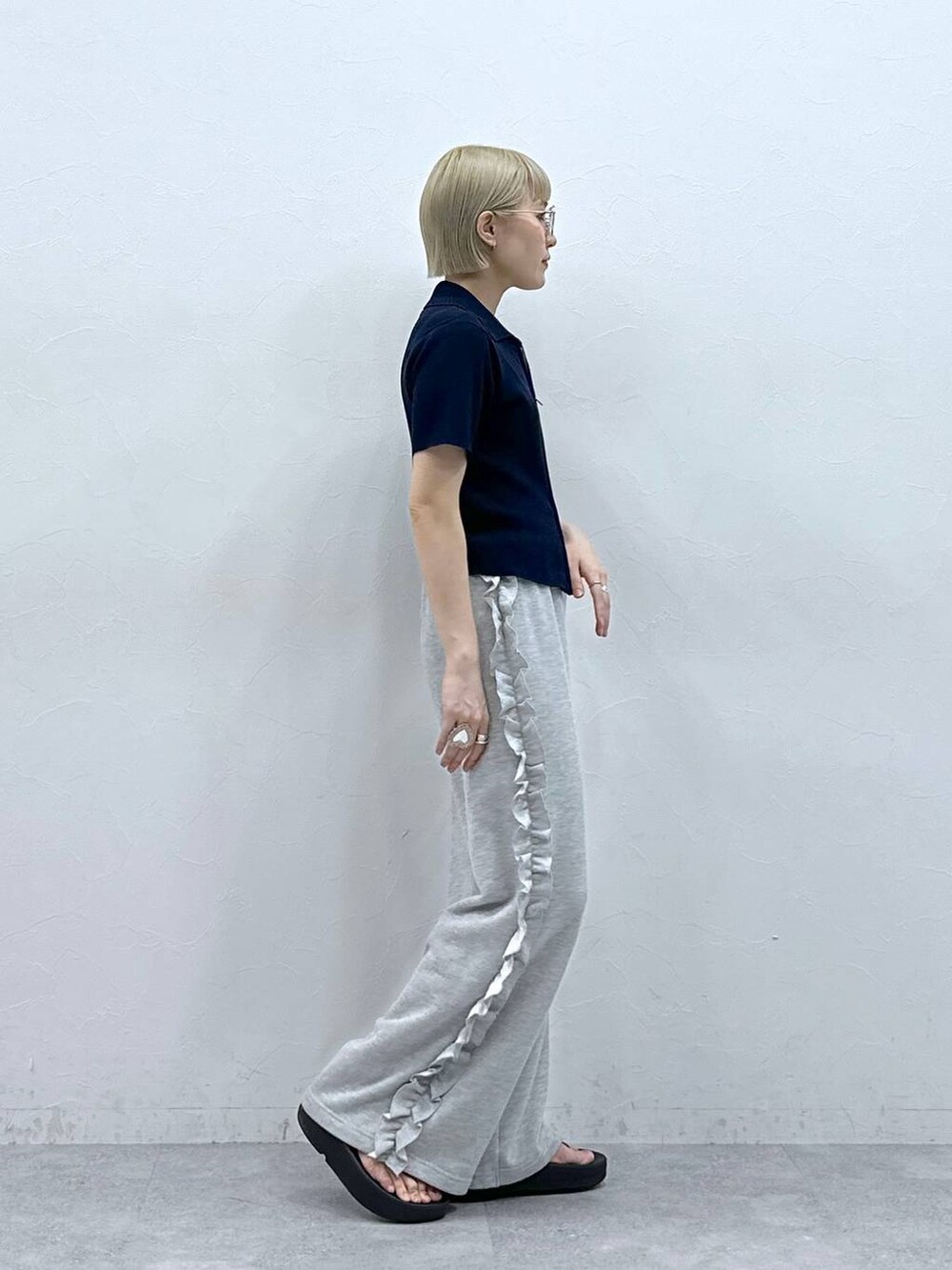 グレー系のスウェットパンツ、ブルー系のニット/セーター、ブラック系のサンダルを着用したレディースの夏コーディネートの5枚目の写真