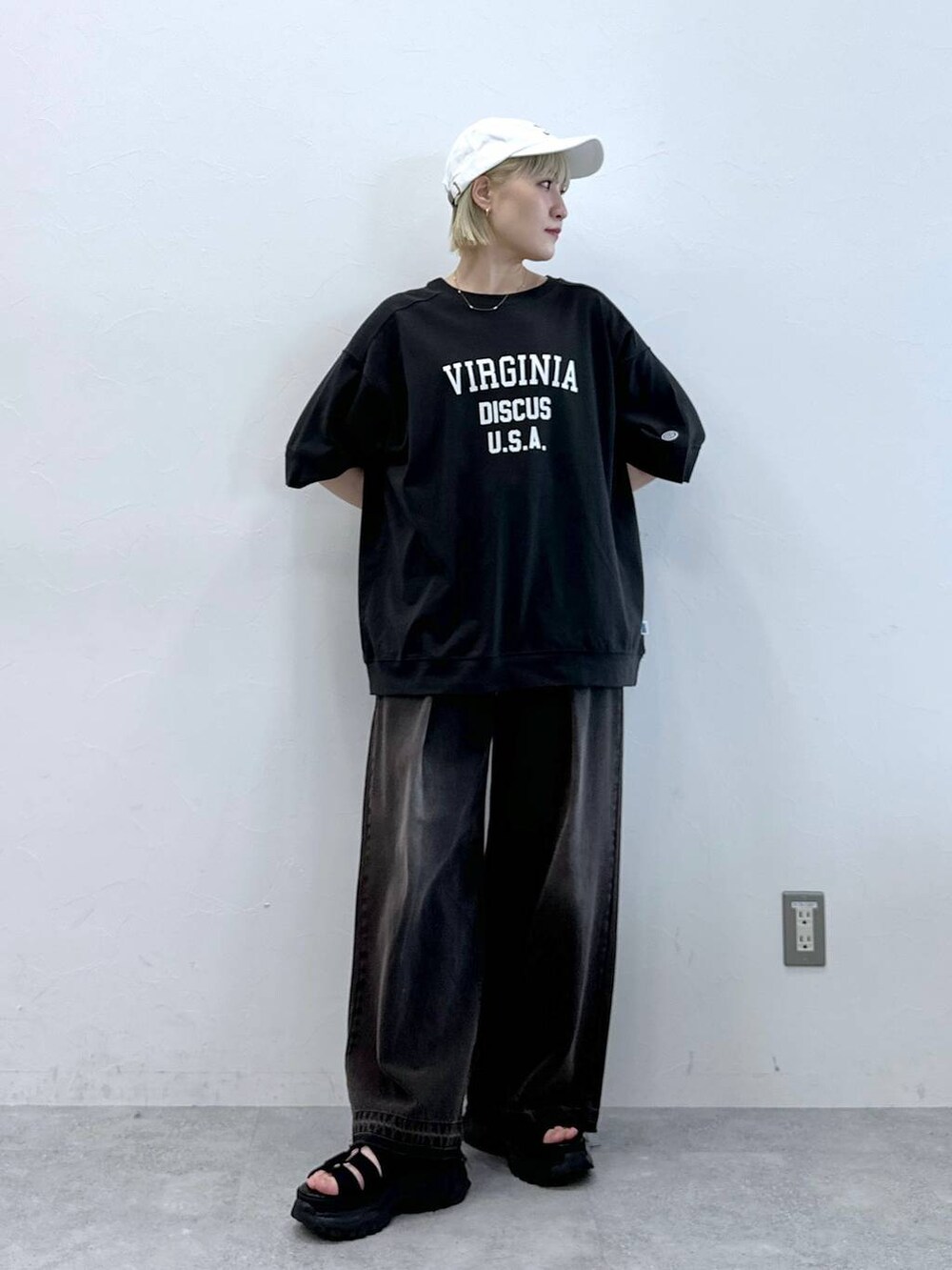 ブルー系のデニムパンツ、ブラック系のサンダル、ホワイト系のTシャツ/カットソーを着用したレディースの夏コーディネートの2枚目の写真