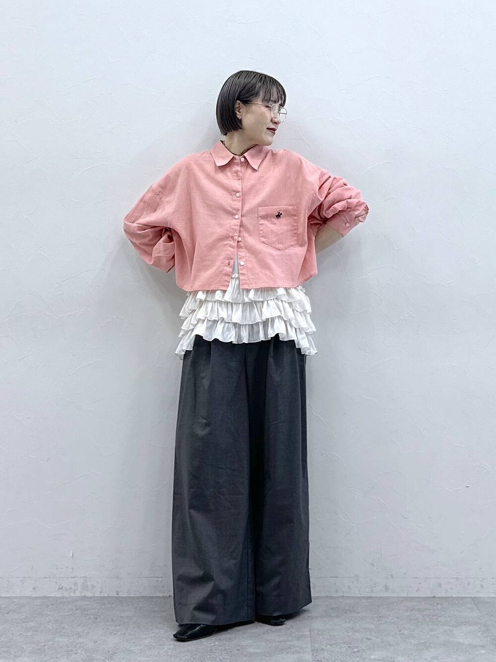 ホワイト系のキャミソール、ピンク系のシャツ/ブラウス、グレー系のスラックスを着用したレディースの春コーディネートの3枚目の写真