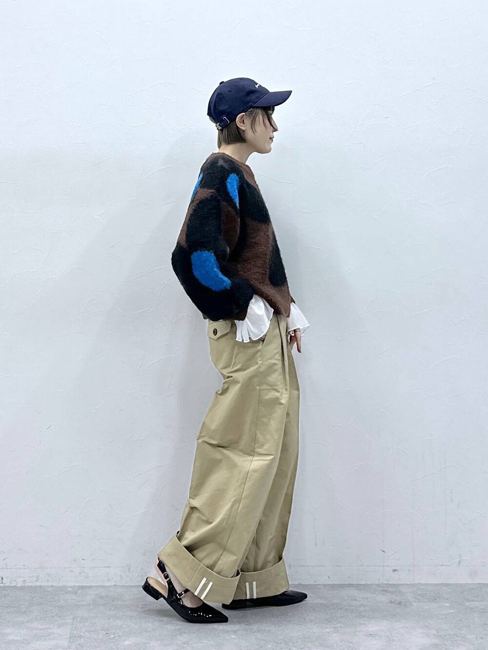 ブラウン系のニット/セーター、ブラック系のパンプス、ベージュ系のチノパンツを着用したレディースの冬コーディネートの4枚目の写真