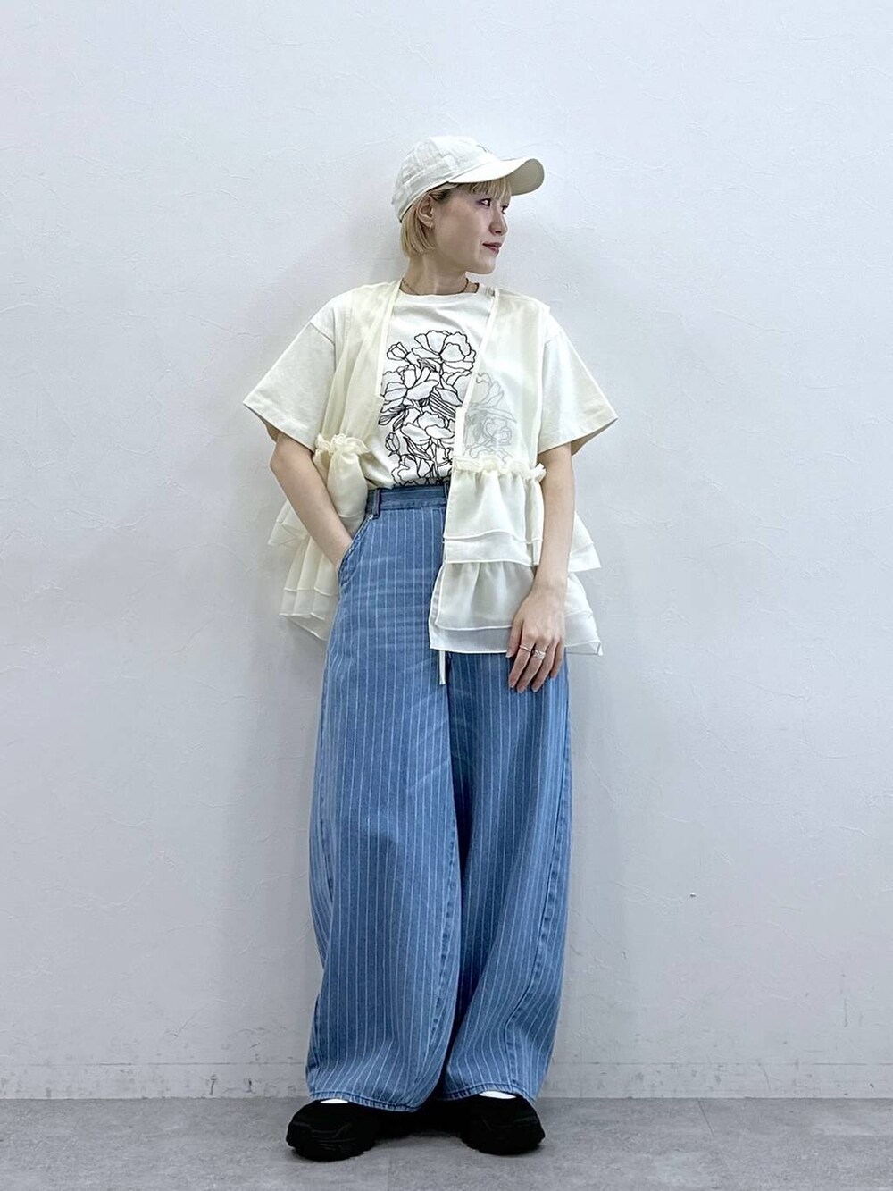 ブラック系のサンダル、ホワイト系のTシャツ/カットソー、ホワイト系のベストを着用したレディースの春コーディネートの4枚目の写真