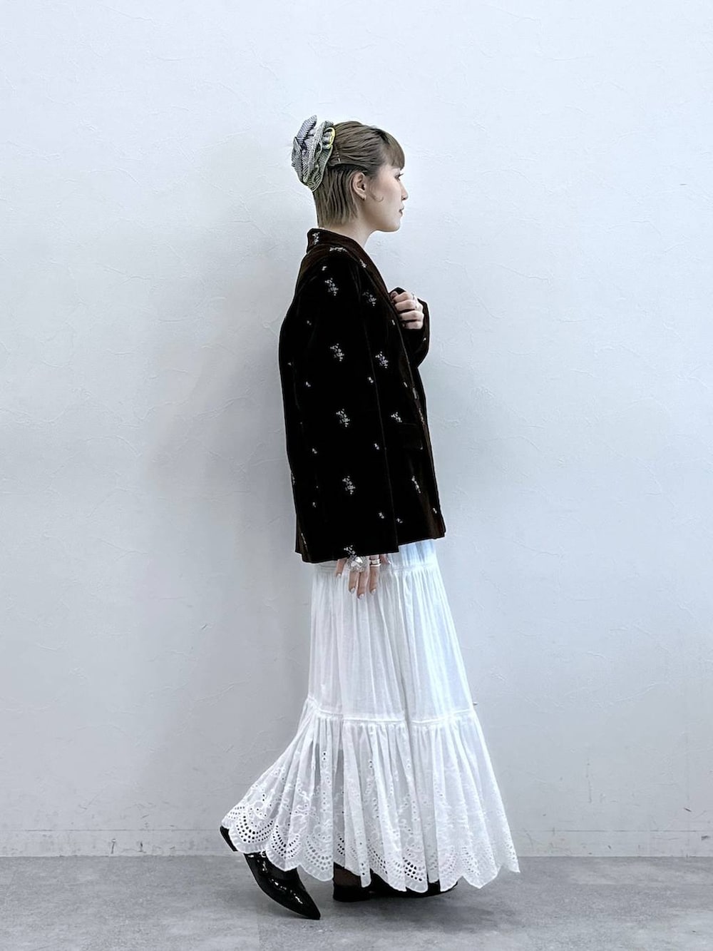 ブラック系のパンプス、ブラック系のテーラードジャケット、ホワイト系のスカートを着用したレディースの冬コーディネートの4枚目の写真