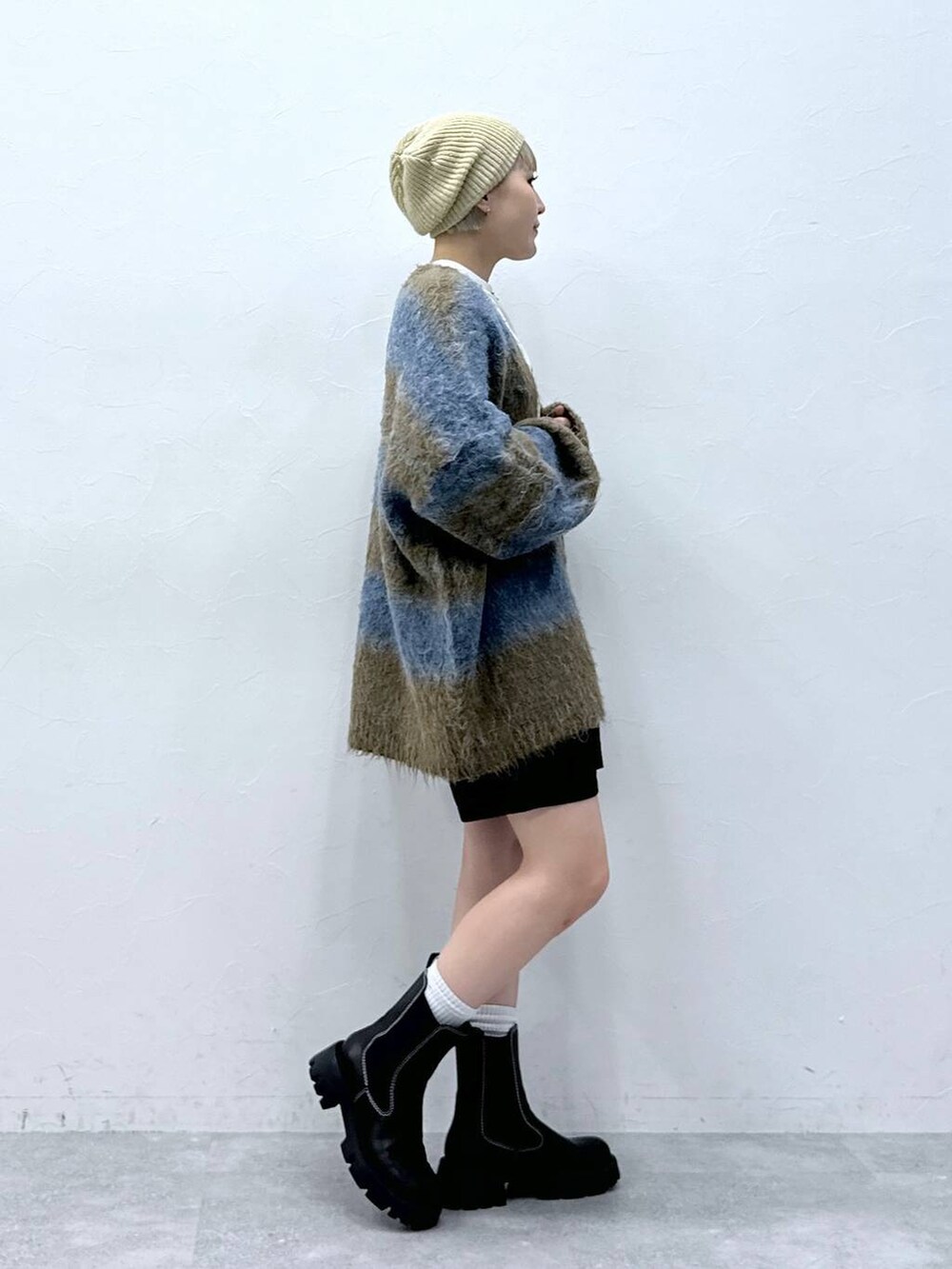 ブラック系のチノパンツ、ホワイト系のTシャツ/カットソー、ブラック系のブーツを着用したレディースの秋コーディネートの4枚目の写真