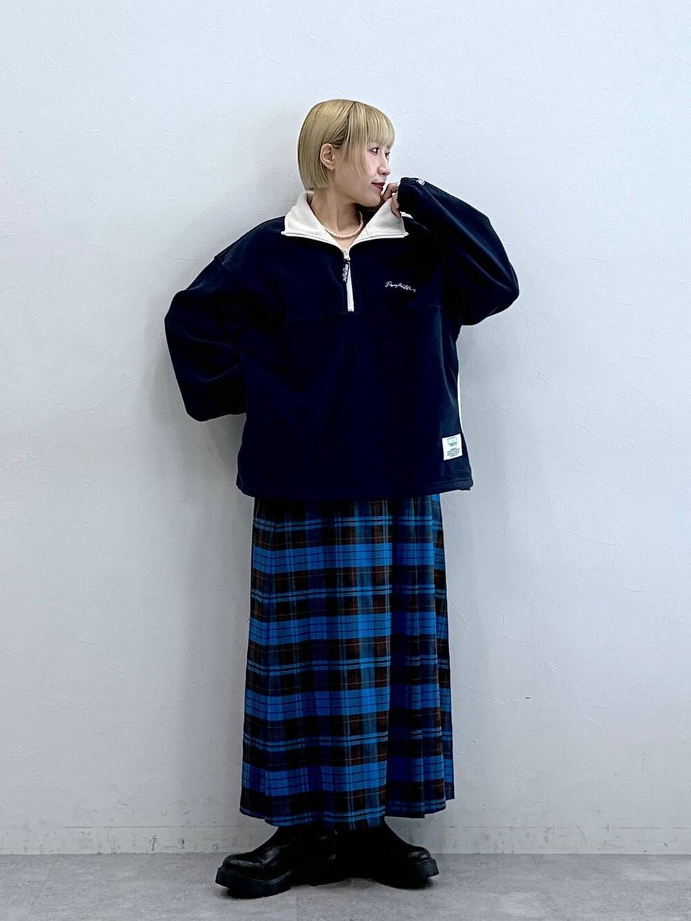 ブルー系のスウェット、ブラック系のブーツ、ブルー系のスカートを着用したレディースの秋コーディネートの4枚目の写真