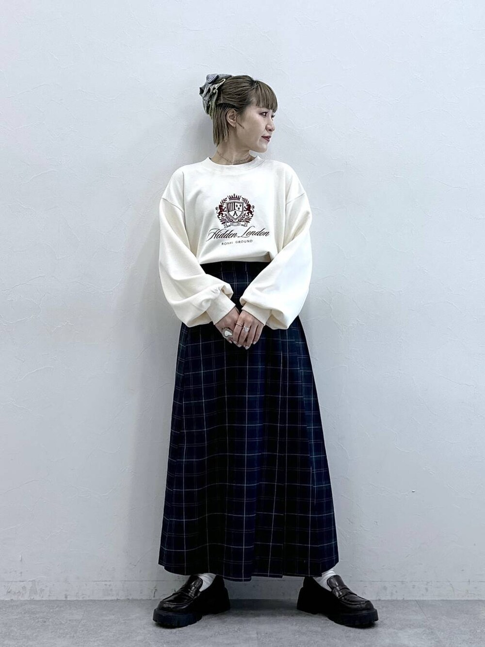 ブラウン系のローファー、グリーン系のスカート、ホワイト系のスウェットを着用したレディースの冬コーディネートの3枚目の写真