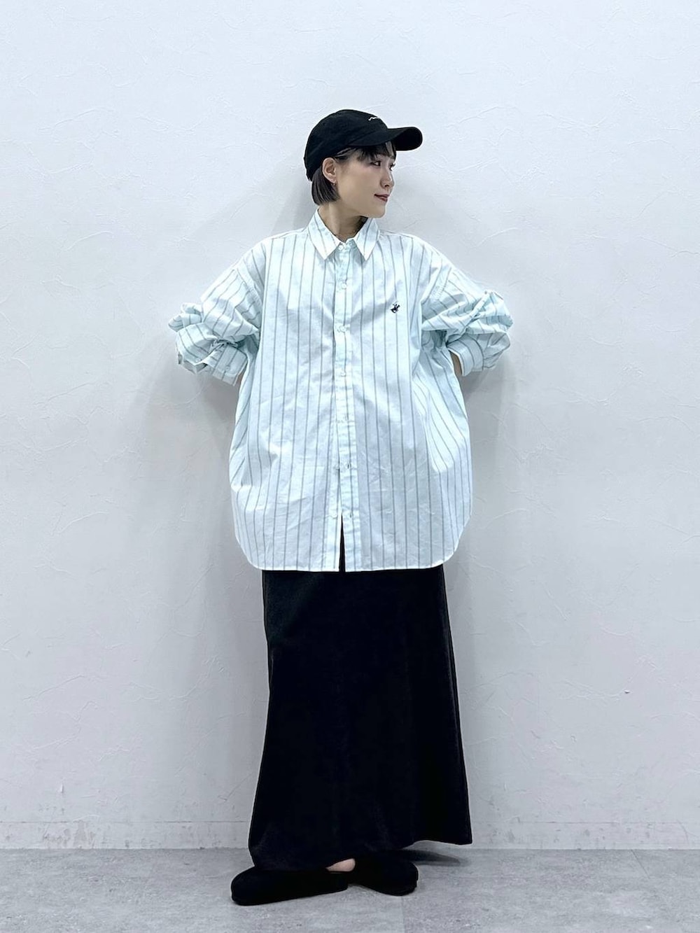 グリーン系のシャツ/ブラウス、ブラック系のモカシン/デッキシューズ、ブラック系のスカートを着用したレディースの春コーディネートの3枚目の写真