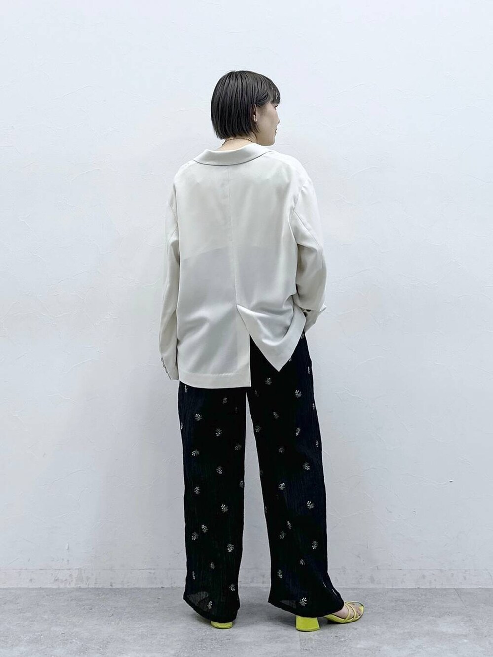 ブラック系のスラックスを着用したレディースの春コーディネートの6枚目の写真