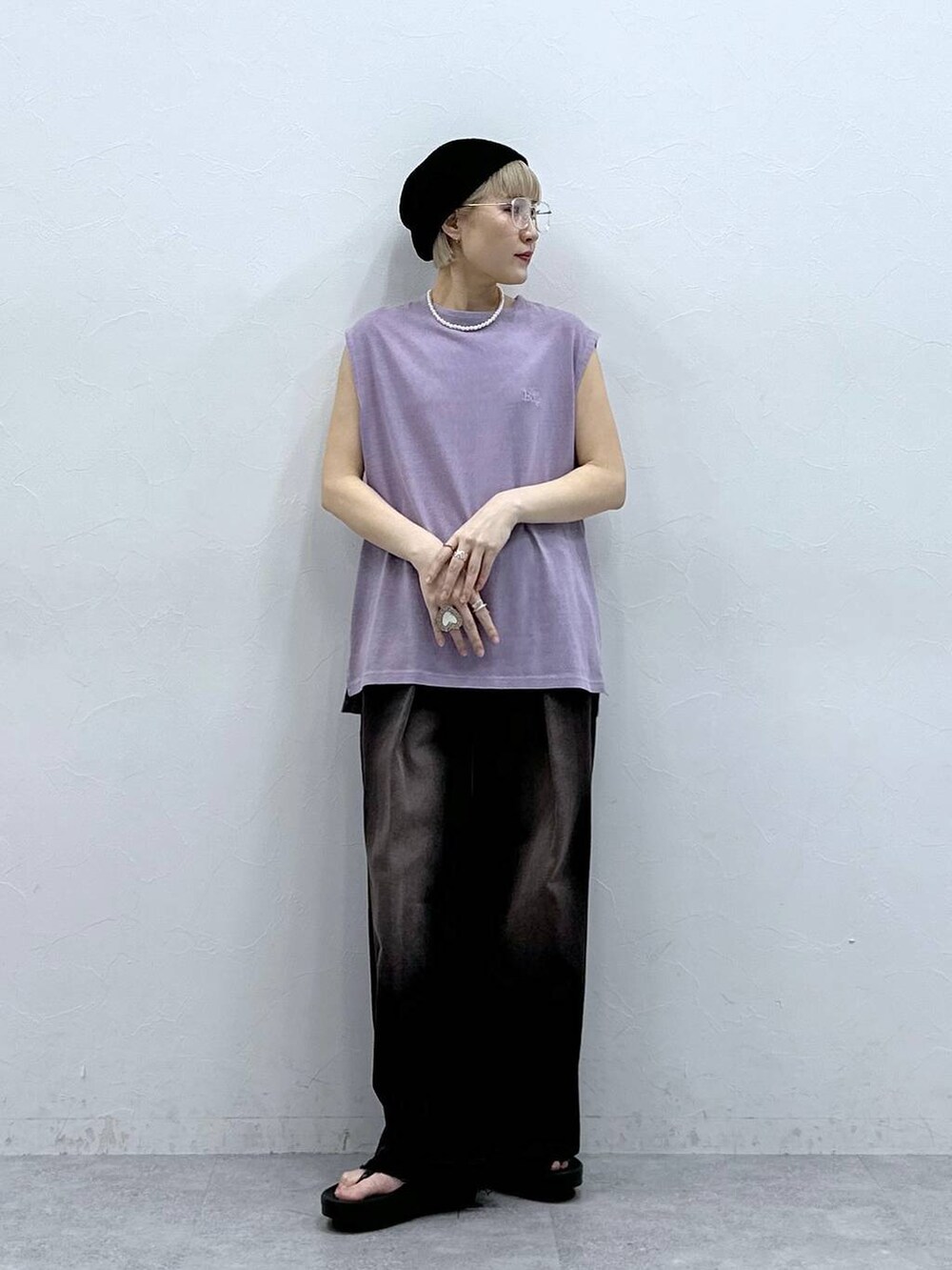 ブラック系のデニムパンツ、パープル系のTシャツ/カットソー、ブラック系のサンダルを着用したレディースの夏コーディネートの3枚目の写真