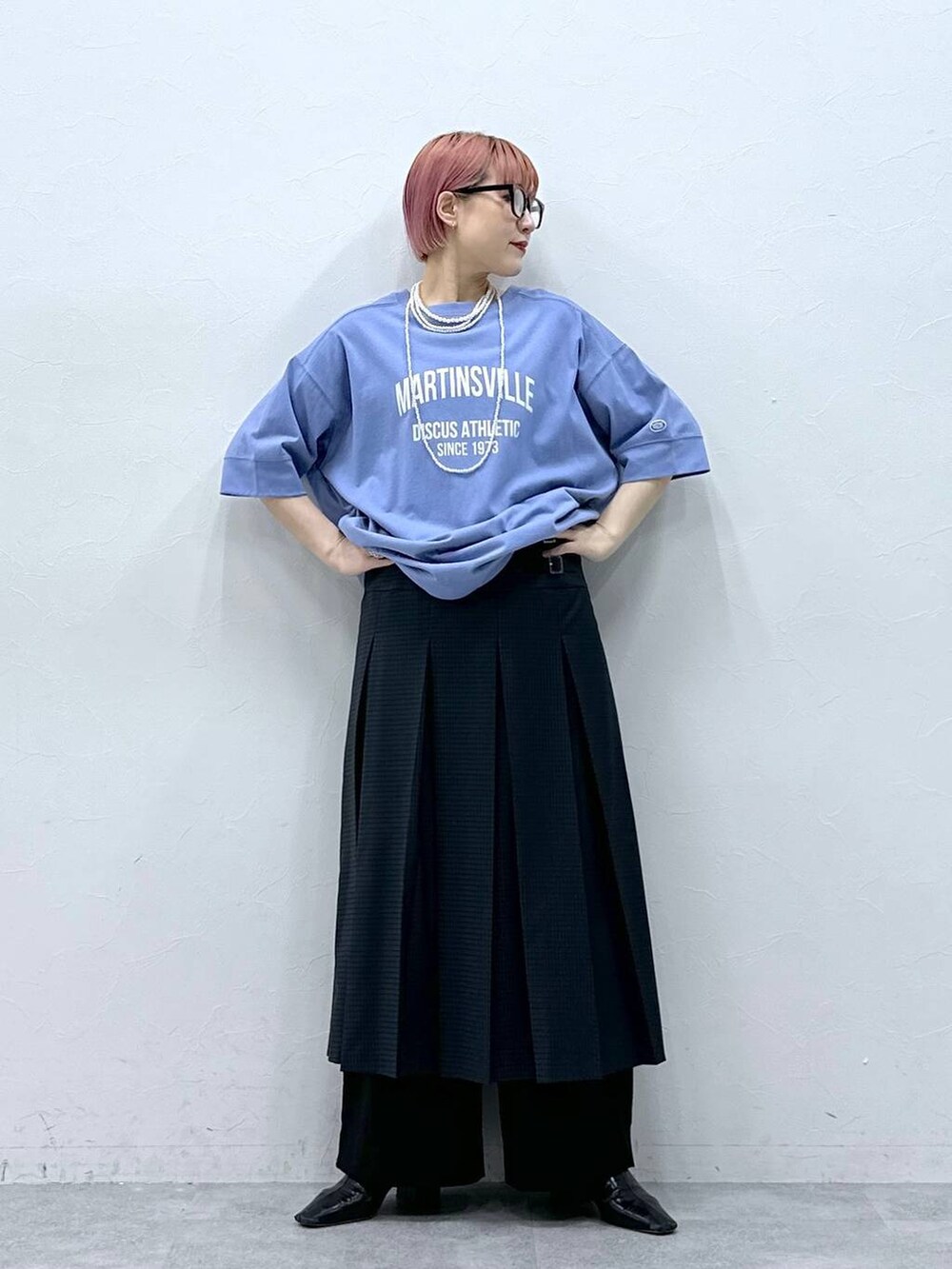 ブラック系のスラックス、ブルー系のTシャツ/カットソー、グレー系のスカートを着用したレディースの春コーディネートの3枚目の写真