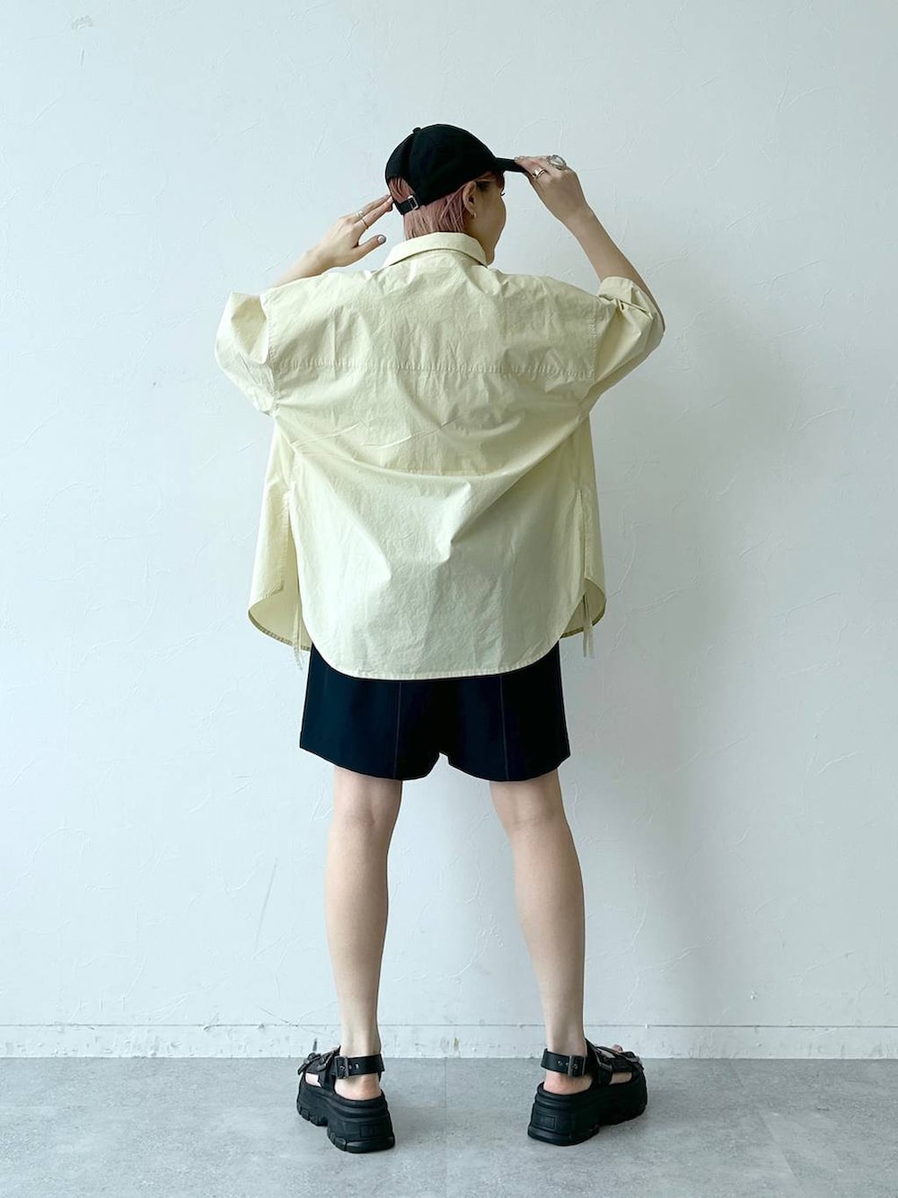 ブラック系のサンダル、ブルー系のスラックス、イエロー系のシャツ/ブラウスを着用したレディースの春コーディネートの5枚目の写真