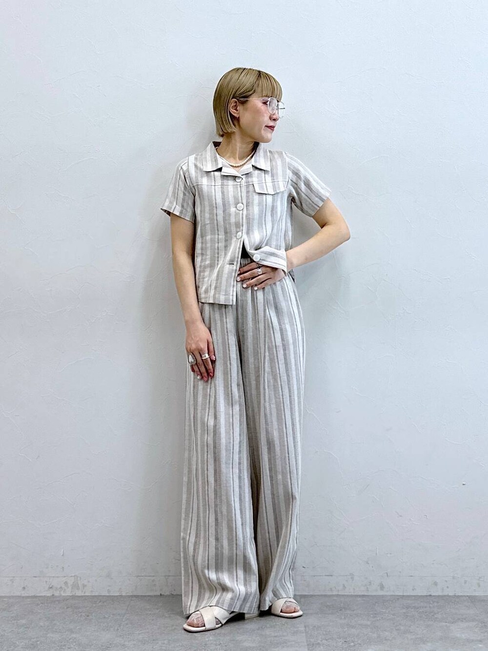 ベージュ系のシャツ/ブラウス、ベージュ系のその他パンツ、ブラック系のメガネを着用したレディースの夏コーディネートの2枚目の写真