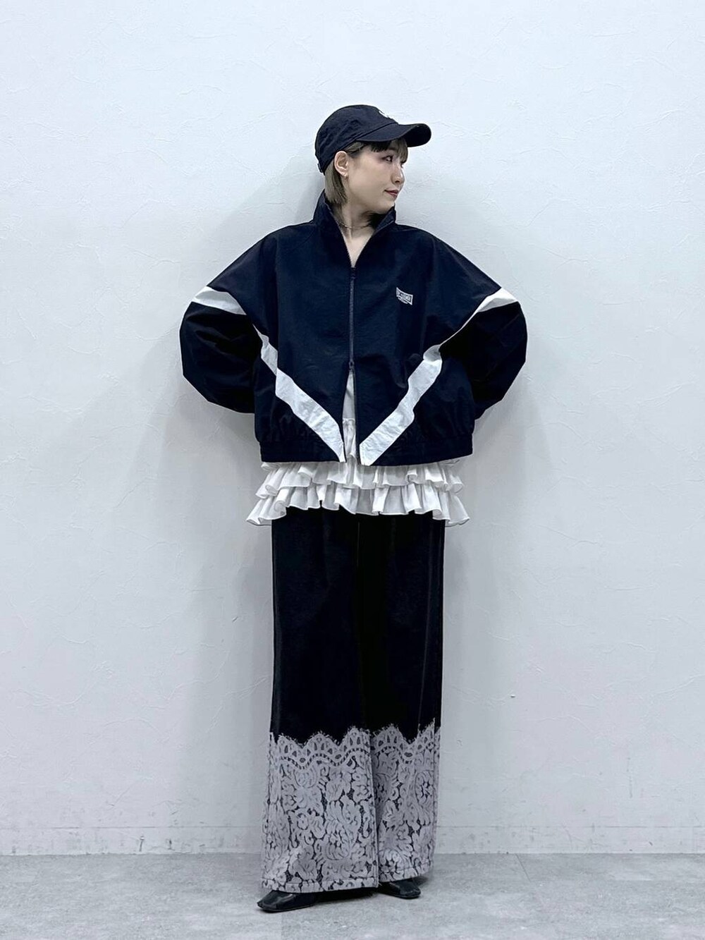 ホワイト系のキャミソール、ブルー系のブルゾン、ブラック系のデニムパンツを着用したレディースの冬コーディネートの2枚目の写真