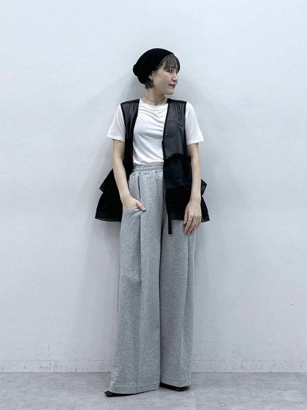 グレー系のスウェットパンツ、ホワイト系のTシャツ/カットソー、ブラック系のベストを着用したレディースの春コーディネートの6枚目の写真