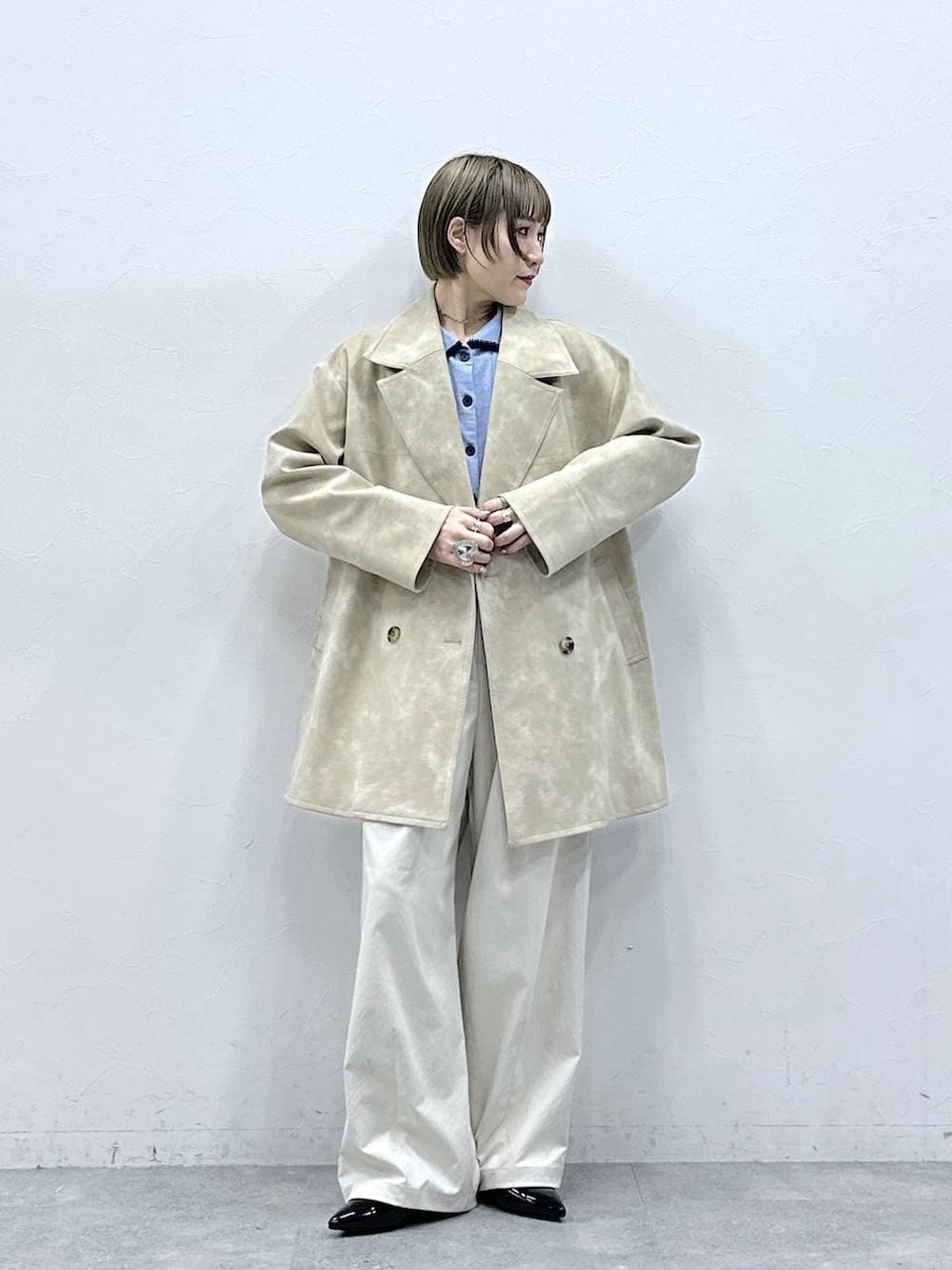 ホワイト系のチノパンツ、ブラック系のパンプス、ブルー系のカーディガン/ボレロを着用したレディースの冬コーディネートの2枚目の写真