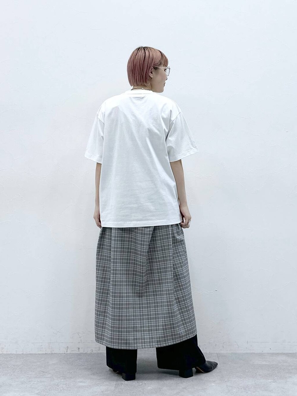 グレー系のワンピース、ホワイト系のTシャツ/カットソー、ブラック系のスラックスを着用したレディースの春コーディネートの6枚目の写真