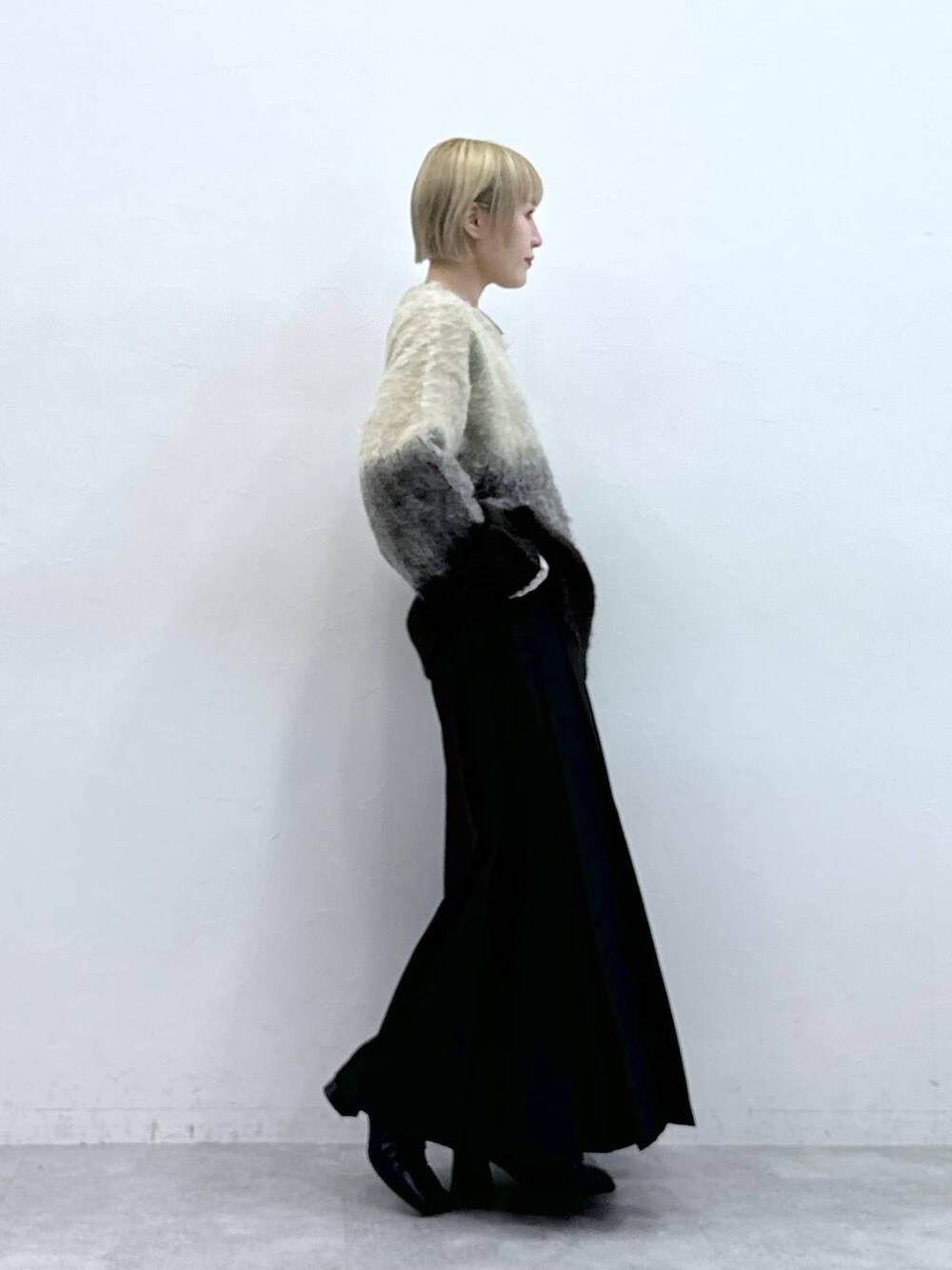 ブラウン系のスカート、ブラウン系のニット/セーターを着用したレディースの秋コーディネートの4枚目の写真