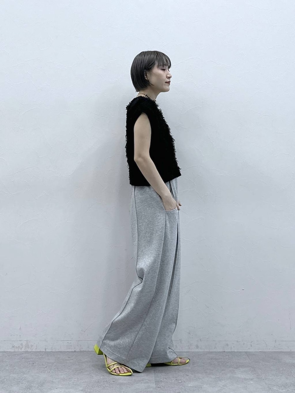 グレー系のスウェットパンツ、ブラック系のベストを着用したレディースの春コーディネートの5枚目の写真