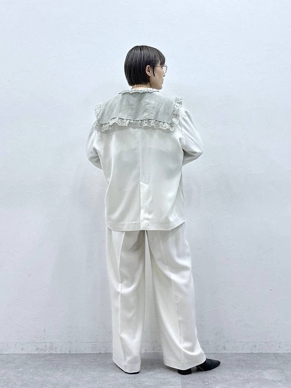 グリーン系のシャツ/ブラウス、ホワイト系のテーラードジャケット、ホワイト系のスラックスを着用したレディースの春コーディネートの6枚目の写真