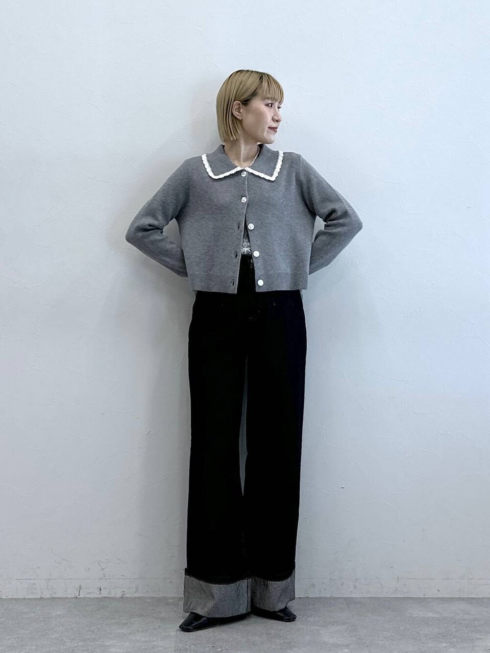 ブラック系のデニムパンツ、ホワイト系のTシャツ/カットソー、グレー系のニット/セーターを着用したレディースの夏コーディネートの2枚目の写真