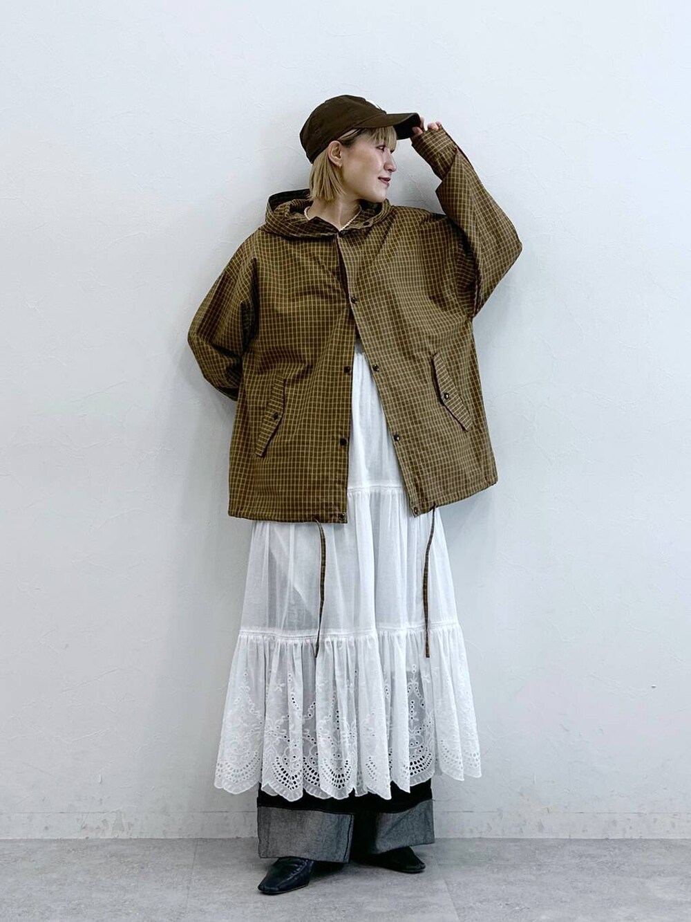 ブラック系のデニムパンツ、イエロー系のシャツ/ブラウス、ホワイト系のスカートを着用したレディースの夏コーディネートの2枚目の写真