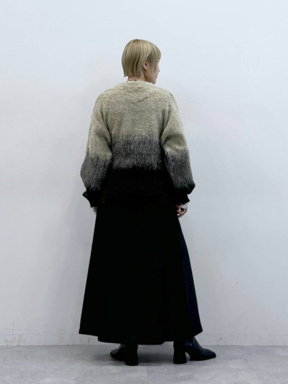 ブラウン系のスカート、ブラウン系のニット/セーターを着用したレディースの秋コーディネートの5枚目の写真