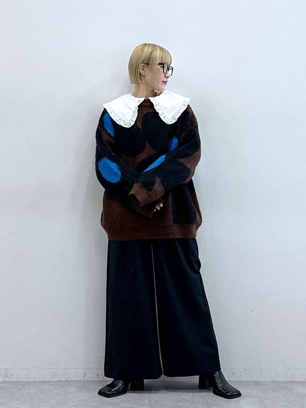 ブラック系のテーラードジャケット、ブラウン系のニット/セーター、ホワイト系のシャツ/ブラウスを着用したレディースの秋コーディネートの2枚目の写真