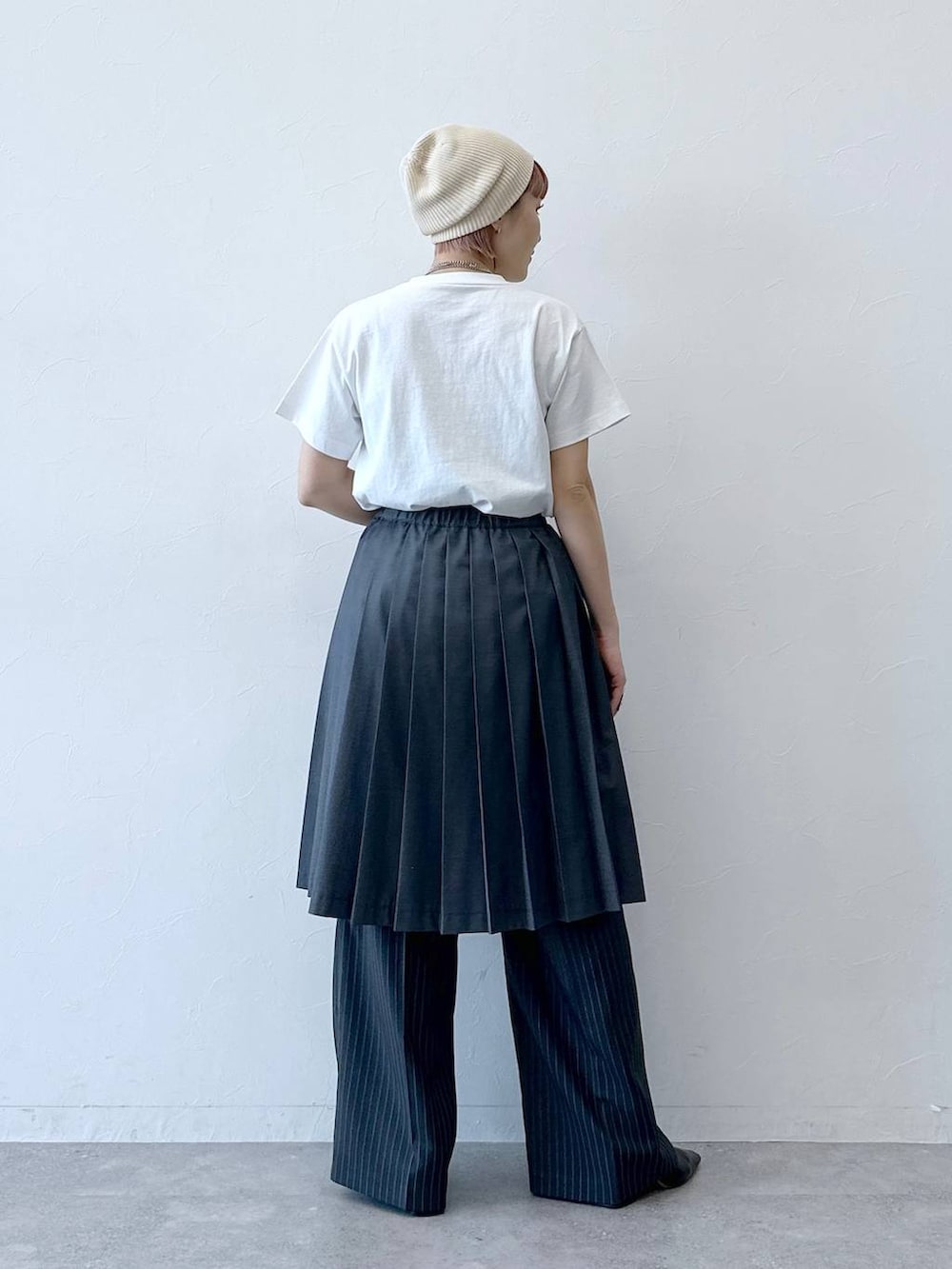 グレー系のスラックス、グレー系のスカート、ホワイト系のTシャツ/カットソーを着用したレディースの春コーディネートの7枚目の写真