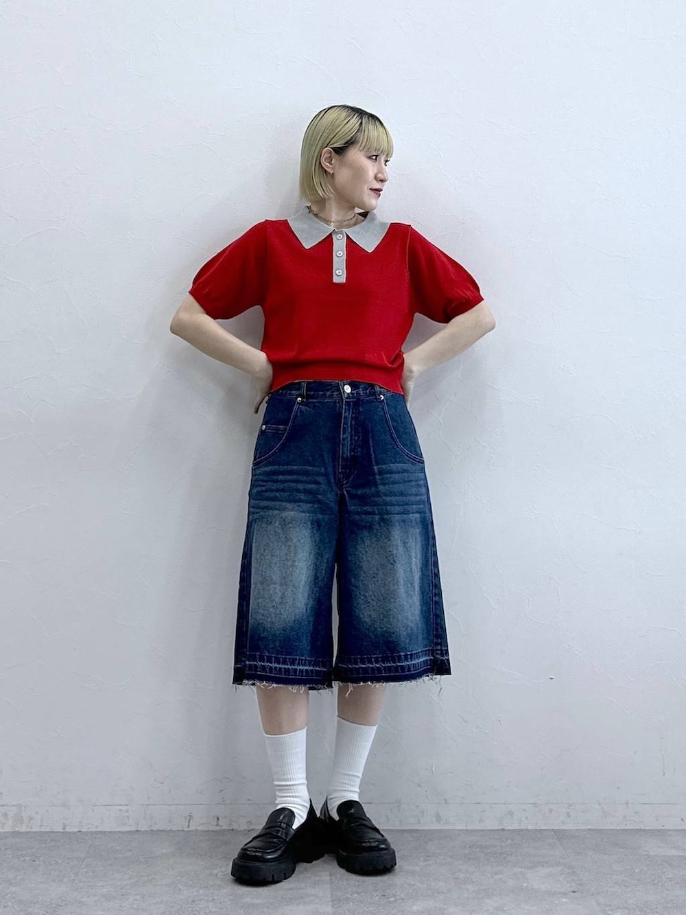 ブルー系のデニムパンツ、ブラック系のローファー、レッド系のポロシャツを着用したレディースの夏コーディネートの3枚目の写真