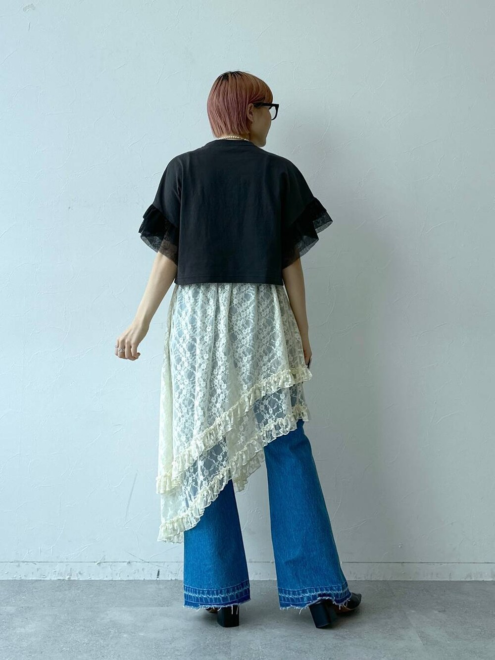 ブルー系のデニムパンツ、ホワイト系のスカート、ブラック系のTシャツ/カットソーを着用したレディースの春コーディネートの6枚目の写真