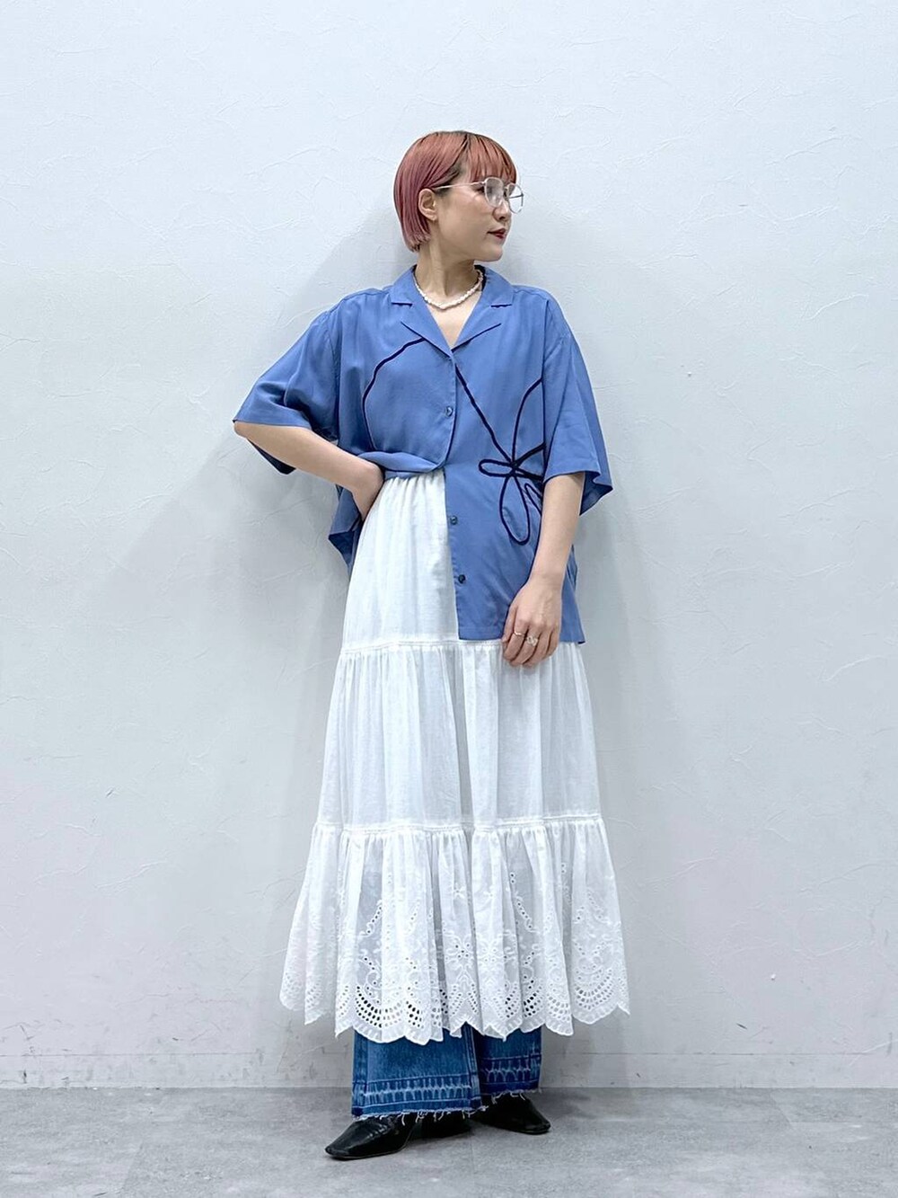 ブルー系のデニムパンツ、ブルー系のシャツ/ブラウス、ホワイト系のスカートを着用したレディースの春コーディネートの3枚目の写真