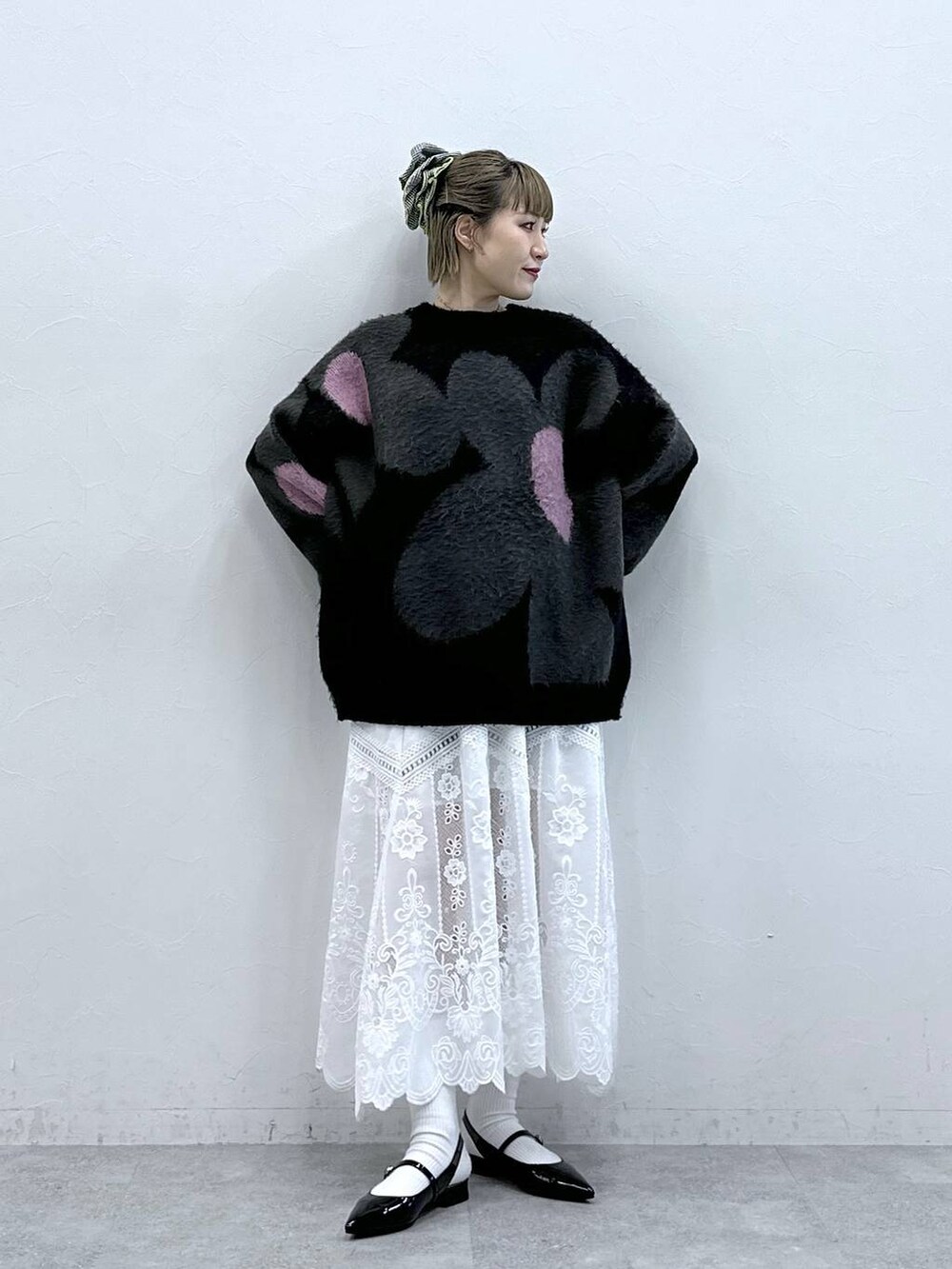 ブラック系のニット/セーター、ホワイト系のスカート、ブラック系のパンプスを着用したレディースの冬コーディネートの4枚目の写真