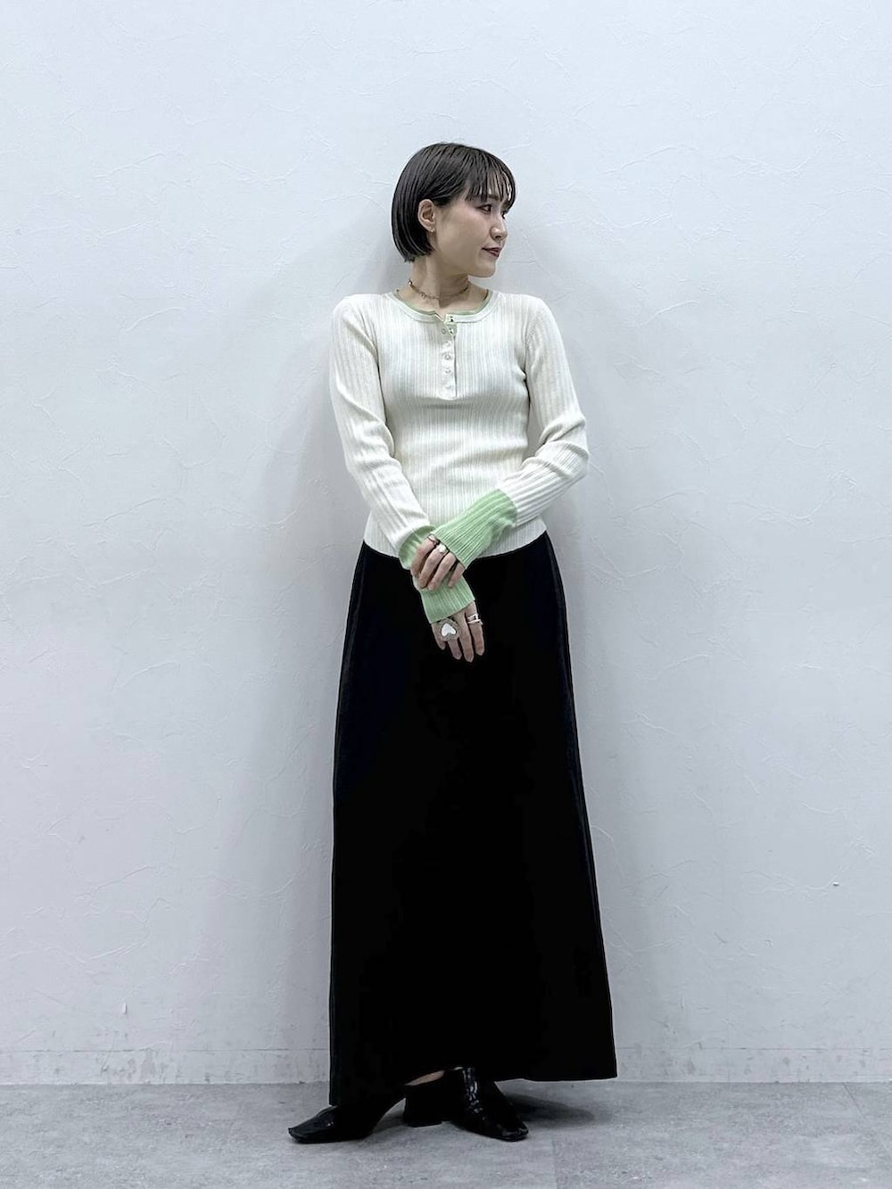 ブラック系のスカート、ホワイト系のニット/セーターを着用したレディースの春コーディネートの4枚目の写真