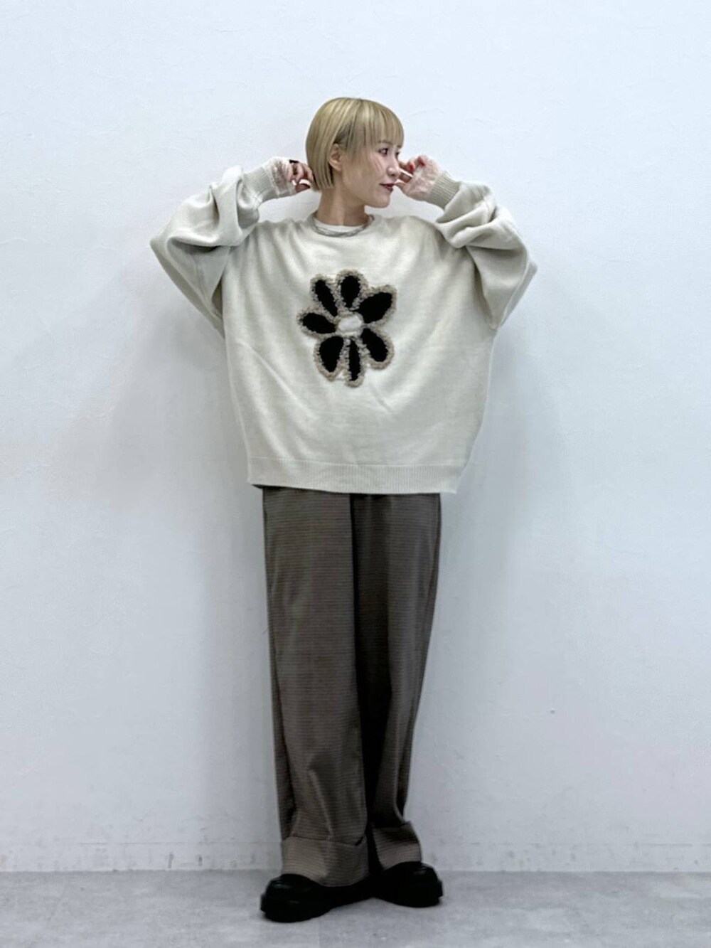 ホワイト系のニット/セーター、ブラック系のローファー、ブラウン系のスラックスを着用したレディースの秋コーディネートの3枚目の写真