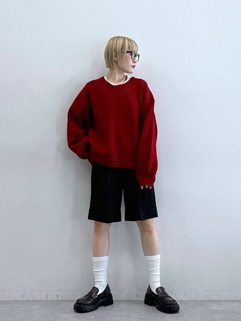 ブラック系のローファー、ブラック系のスラックス、レッド系のニット/セーターを着用したレディースの秋コーディネートの4枚目の写真